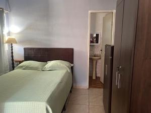 een slaapkamer met een bed en een deur naar een badkamer bij Kit net flor de café in Caparaó Velho