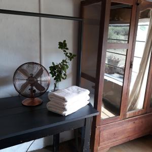 un ventilador sentado en una mesa junto a una ventana en Saffier river cottage Farmstay en Lady Grey