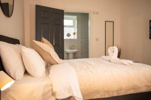 a bedroom with a bed with a stuffed animal on it at Principality Suites - Two Bed Apartment by Property Promise in Cardiff