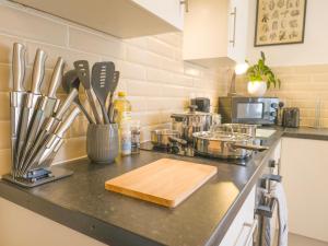 a kitchen counter with a cutting board and utensils at Principality Suites - Two Bed Apartment by Property Promise in Cardiff