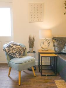 a living room with a chair and a table with a lamp at Principality Suites - Two Bed Apartment by Property Promise in Cardiff