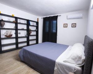a bedroom with a bed and a book shelf at Appartamento sul mare in Su Forti