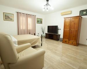 a living room with a bed and a couch and a television at Appartamento sul mare in Su Forti