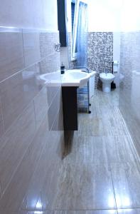a bathroom with a sink and a toilet at Appartamento sul mare in Su Forti