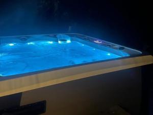 eine Whirlpool-Badewanne mit blauer Beleuchtung in einem Zimmer in der Unterkunft Villa Sudenkolo with outdoor jacuzzi and log sauna in Syöte