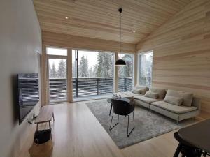 - un salon avec un canapé et une table dans l'établissement Villa Sudenkolo with outdoor jacuzzi and log sauna, à Syöte