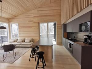 eine Küche und ein Wohnzimmer mit einem Sofa und einem Tisch in der Unterkunft Villa Sudenkolo with outdoor jacuzzi and log sauna in Syöte
