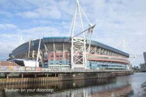 a stadium on a river next to a body of water at Principality Suites - Two Bed Apartment by Property Promise in Cardiff