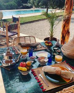 una mesa con platos de comida y fruta. en Villa Des Arganiers en Essaouira