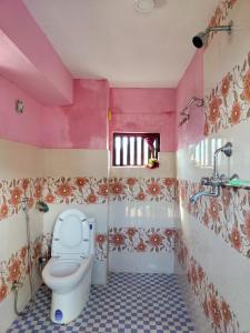 baño con aseo y paredes de color rosa en Nepal Village Local Family Stay, en Bandipur