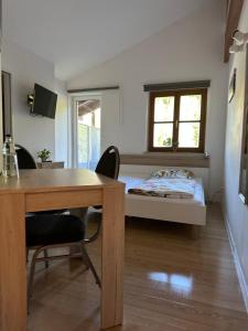 a room with a desk and a bed with a window at Manthaler in Berg am Starnberger See