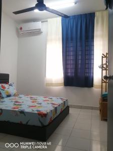 - une chambre avec un lit et un ventilateur de plafond dans l'établissement Jannah Guest House Putrajaya, à Putrajaya