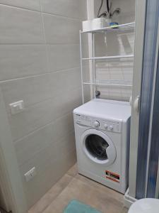 y baño con aseo y lavadora y secadora. en Mare DiVino, en Marsala