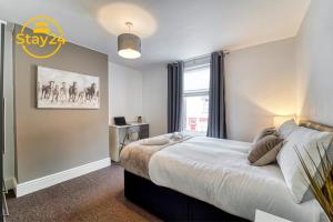 a bedroom with a large bed and a window at Cosy Carlton in Stoke on Trent