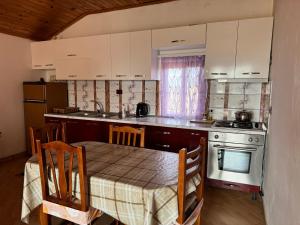 a kitchen with a table and a stove top oven at Vila Deda in Lezhë