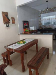 卡波布里奧的住宿－Casa de praia em Unamar com piscina，一间厨房,内设桌子和长凳