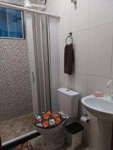 uma casa de banho com um chuveiro, um WC e um lavatório. em Casa de praia em Unamar com piscina em Cabo Frio