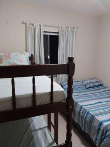 um quarto com um beliche e uma janela em Casa de praia em Unamar com piscina em Cabo Frio
