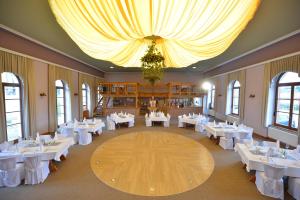 a banquet hall with white tables and a chandelier at Der Bayerische Hof in Grünbach +21 photos