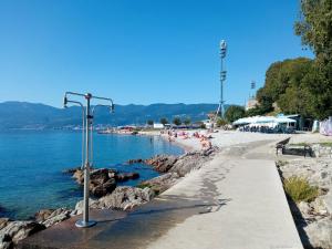 a beach with people on the sand and the water at Guesthouse Gasho in Rijeka