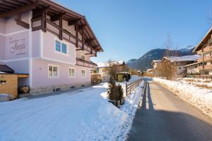 a snow covered street next to a building at Landhaus Josefa in Flachau