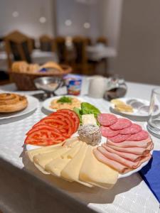 eine Platte mit Fleisch und Käse auf dem Tisch in der Unterkunft Ośrodek Tulipan in Ustroń