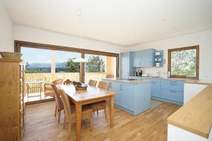 a kitchen with blue cabinets and a table with chairs at Casa Montagna in Oy-Mittelberg