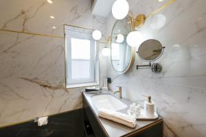 a bathroom with a sink and a mirror at Yasu Luxury Rooms in Bucharest
