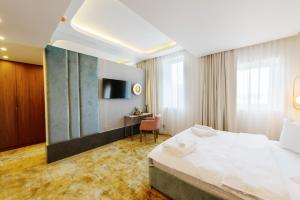 a hotel room with a bed and a desk at Yasu Luxury Rooms in Bucharest