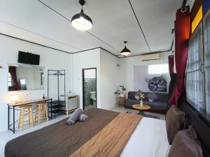 THE NAIYANGHOUSE في شاطئ ناي يانغ: غرفة نوم بسرير كبير وغرفة معيشة