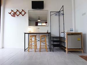 Cette chambre comprend un comptoir avec tabourets et un miroir. dans l'établissement THE NAIYANGHOUSE, à Nai Yang Beach