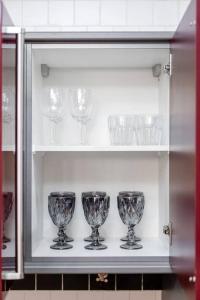 four glass wine glasses sitting on a shelf at Spacious 2BR apartment in Marina Crown in Dubai