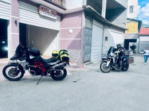 dos motocicletas estacionadas frente a un garaje en Hotel Reci, en Peshkopi