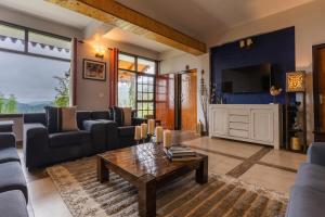 un salon avec un canapé et une table basse dans l'établissement SaffronStays The Clairmont Cottage,Mukteshwar, à Mukteswar