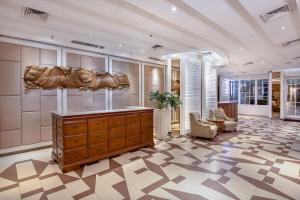 a lobby with a wooden dresser in a room at THE 1O1 Bogor Suryakancana in Bogor
