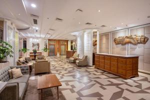 a lobby with couches and chairs and a table at THE 1O1 Bogor Suryakancana in Bogor