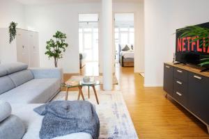 a living room with a couch and a tv at Design City Apartment, Modern, ebenerdig, Top Lage in Weinheim