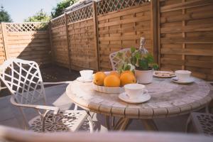 a table with oranges and cups on a patio at Naturnahes Familienchalet mit Garten - Wifi - Netflix - nur 15 Minuten vom Chiemsee und 35 Minuten von München entfernt in Vogtareuth