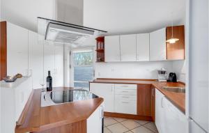 Una cocina con gabinetes blancos y un fregadero. en Holiday Home Tranebærvej Denm, en Hemmet