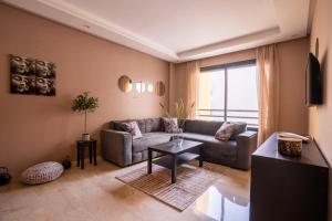 uma sala de estar com um sofá e uma mesa em Suite Apt Bourgogne N°2, 2 P em Casablanca