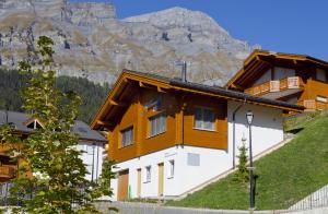 un bâtiment avec une montagne en arrière-plan dans l'établissement Apartments Residenz Iris, à Loèche-les-Bains