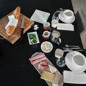 czarny stół z talerzami i naczyniami w obiekcie Chambre au coeur des vignes w mieście Myans