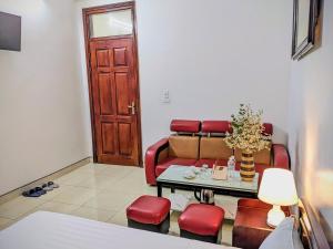 a living room with a table and red chairs at Trường Yến Hotel Ninh Bình in Ninh Binh