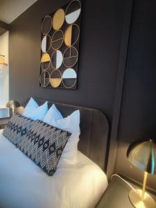 1 dormitorio con cama con almohada y espejo en Studio Esplanade bord du Lac, en Aix-les-Bains