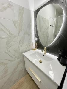 a bathroom with a white sink and a mirror at Studio Esplanade bord du Lac in Aix-les-Bains