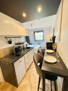 a kitchen with a table and chairs in a room at Studio Esplanade bord du Lac in Aix-les-Bains