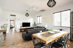 uma sala de estar com um sofá e uma mesa em Haven on Noosa Hill - sunset views, pools, spa em Noosa Heads