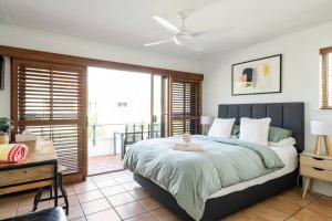 Haven on Noosa Hill - sunset views, pools, spa في نوسا هيدز: غرفة نوم بسرير كبير وبلكونة