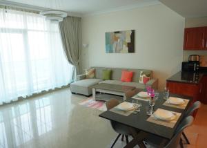 a living room with a table and a couch at Cozy 1BH Apt next to the sea! in Ajman 