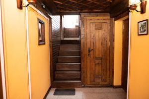 a hallway with a wooden door and stairs at Къща ЕТНО in Koprivshtitsa